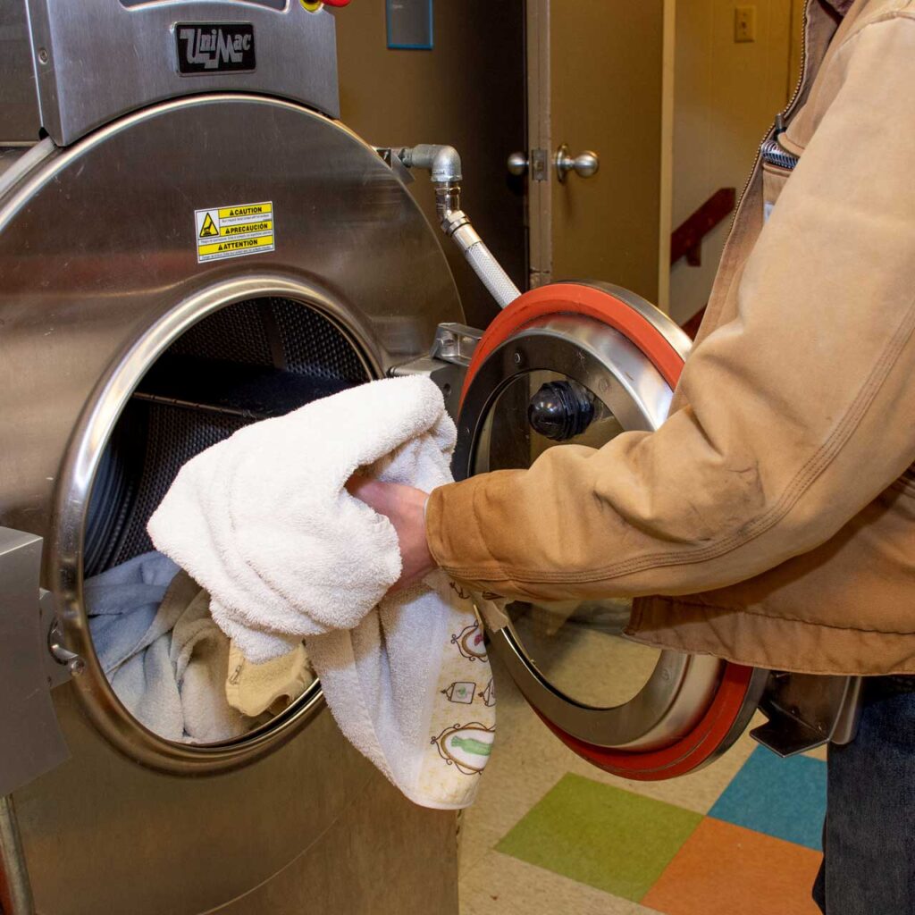 Volunteer pulling towel out of laundry machine