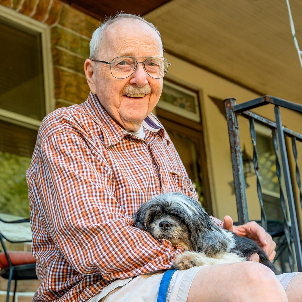 Senior citizen with dog in lap