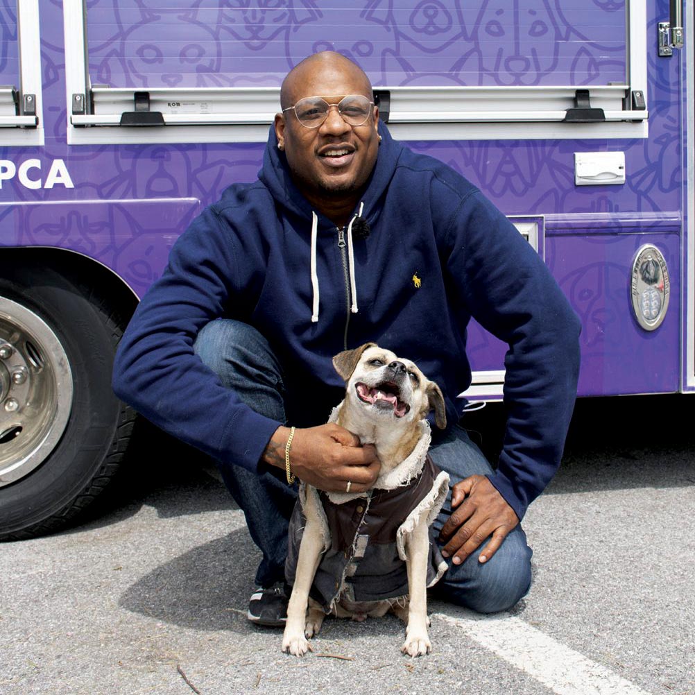 Person petting bulldog outside