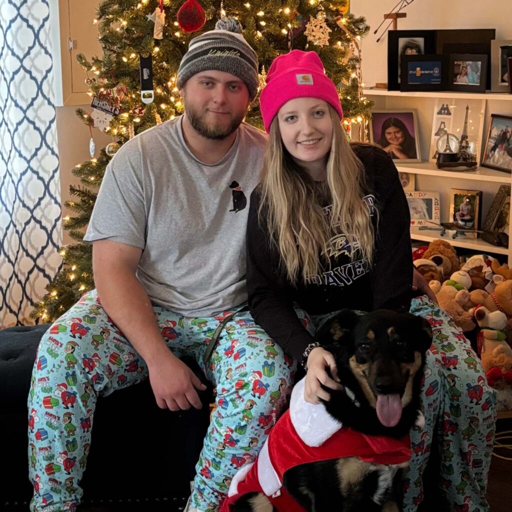 Man and woman in pajamas with dog on Christmas