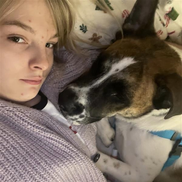 Person and dog snuggling in a bed